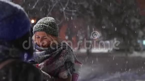 一群快乐的朋友在大雪下散步手里拿着纸杯玩雪玩得很开心人民视频的预览图