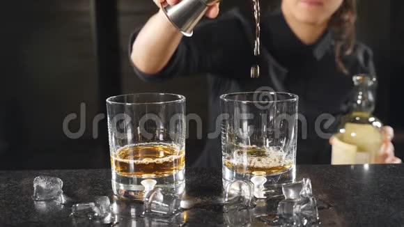 女调酒师慢慢地从跳汰机里倒出威士忌不可辨认的穿黑色衬衫的女酒吧高清高清视频的预览图