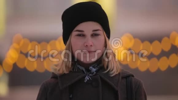 女人在冬夜城市戴着大耳机视频的预览图