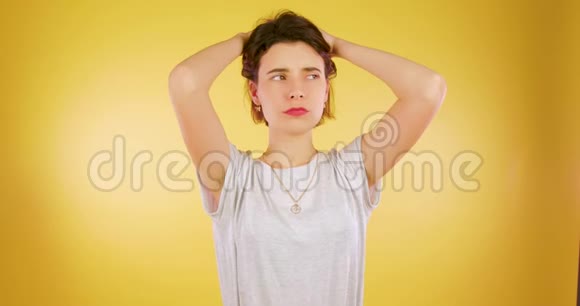疲惫的白种人布鲁内特女孩站在黄色的背景和沉重的叹息视频的预览图