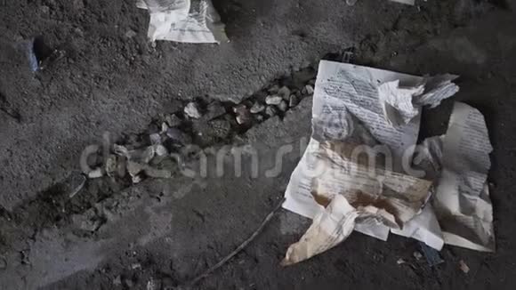 一座废弃的建筑的混凝土地板上躺着一本皱巴巴的书页酒杯掉在地上视频的预览图