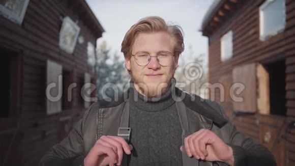 一个英俊的留胡子的家伙的肖像戴着一件温暖的毛衣和敞开的夹克他笑了笑停下来视频的预览图