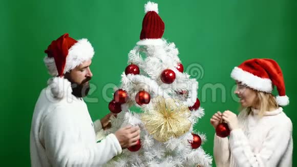 新年的男人和女人头在绿色的背景上装饰圣诞树庆祝新年和视频的预览图
