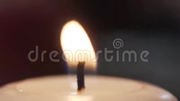 一支燃烧的蜡烛的近景火焰迎风招展宏射浪漫气氛视频的预览图