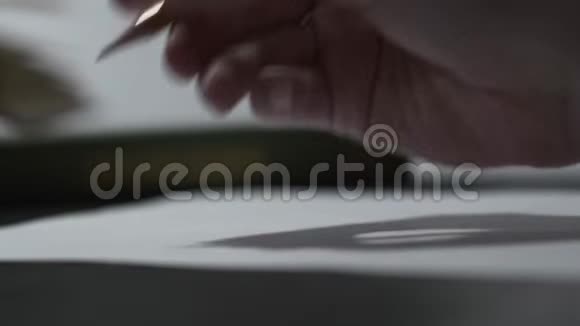 女性用铅笔在白纸上写字棕色木笔手中特写视频的预览图