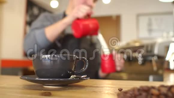 模糊的图像一个人谁倒牛奶到一个杯子在前景是一个杯子视频的预览图