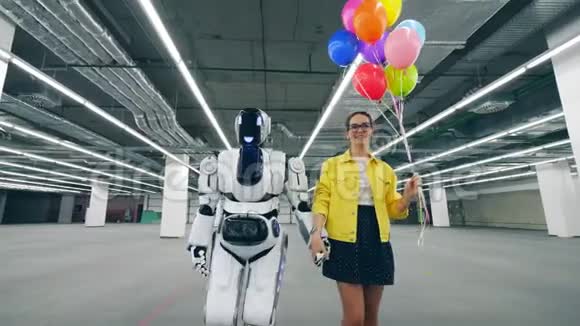 一位女士和一个机器人正一起沿着大厅走视频的预览图