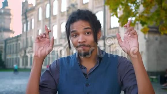非裔美国学生戴着可怕眼镜的特写肖像交叉手指希望能在大学里好运视频的预览图