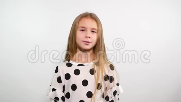 带着黑点的白色上衣微笑的年轻女孩在镜头前亲吻空气视频的预览图