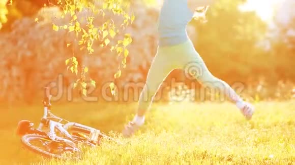快乐的小女孩在阳光明媚的日子在草地上跳舞视频的预览图