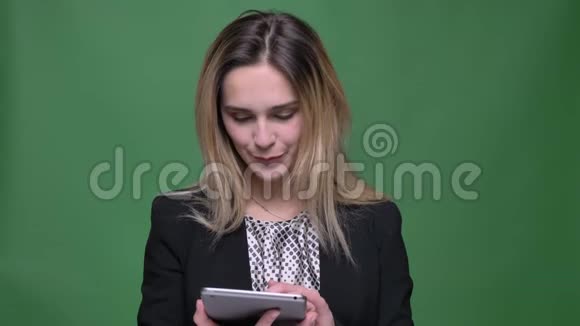 使用平板电脑拍摄年轻迷人的红种人白种人女性特写镜头并在镜头中显示蓝色的色度屏幕视频的预览图