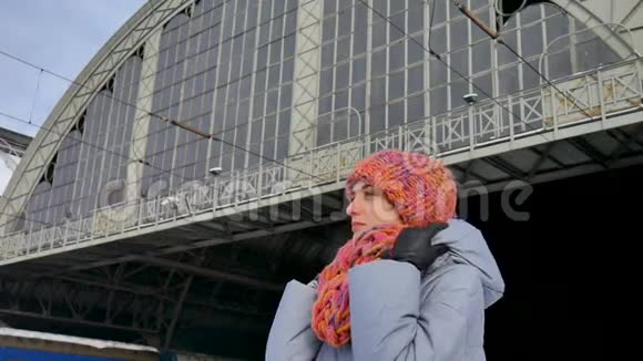在阳光明媚但寒冷的冬日女性旅行者在火车站等候旅程概念视频的预览图