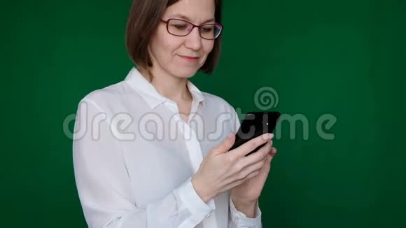在绿色背景下使用智能手机的女人铬钥匙关门视频的预览图