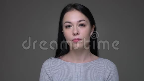 年轻漂亮的黑发白人女性点头同意直视镜头的特写镜头视频的预览图