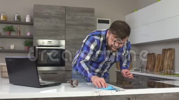 一个白种人打扫卫生洗了厨房里的咖啡一台笔记本电脑慢动作视频的预览图