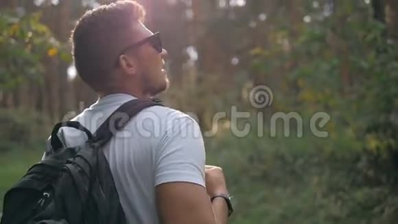 阳光明媚的秋日游客在森林中漫步边休息边呼吸新鲜空气男性戴着时髦的太阳镜视频的预览图