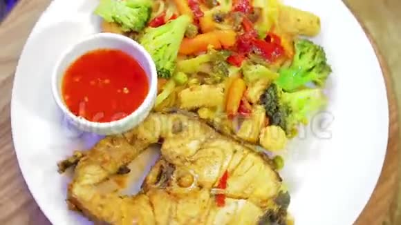一盘白色的鱼和意大利面加上蔬菜和亚洲沙司盘成一个圆圈旋转视频的预览图