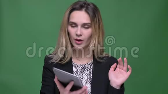 使用平板电脑拍摄年轻迷人的时髦白种人女性的特写镜头并将蓝色屏幕显示在相机上视频的预览图
