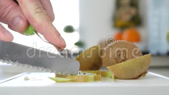 厨房里的男人把新鲜的猕猴桃切成小片做沙拉视频的预览图