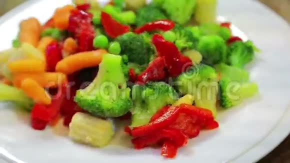 花椰菜玉米胡椒在白色盘子里旋转成一圈视频的预览图