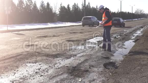 检查员检查和检查道路上的洞坏路视频的预览图