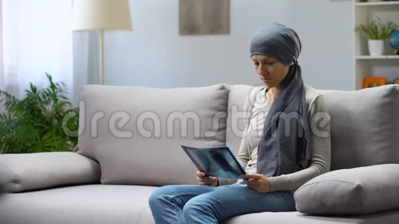 患癌症的女人坐在沙发上看着肺x光希望能治愈视频的预览图