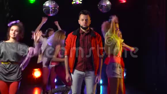 一个男人悲伤地站在一群欢快的人周围跳舞黑色背景视频的预览图