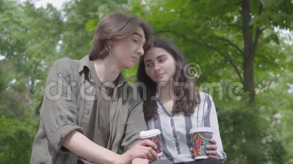 肖像可爱的年轻幸福夫妇穿着休闲服装在公园里一起度过约会学生们视频的预览图