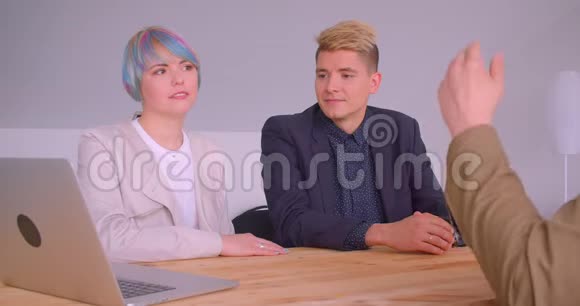 三个商业伙伴在室内咖啡厅用笔记本电脑开会的特写镜头视频的预览图