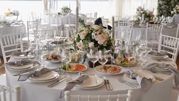 宴会配有大圆桌白色桌布各种美味菜肴鲜花布置和装饰视频的预览图