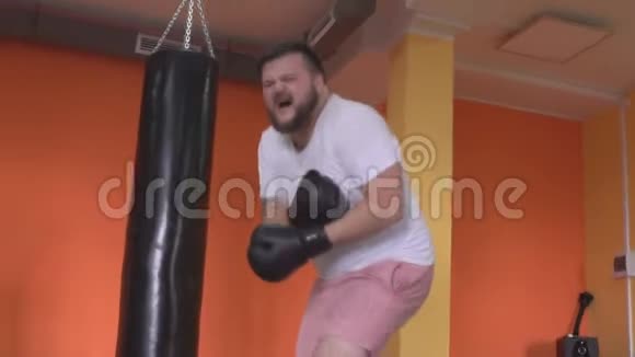 长胡子的白种人男拳击手在疼痛中扭动并威胁到健身房崩溃慢动作视频的预览图