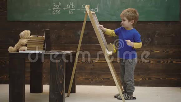 小男孩在黑板上画画小学生擦黑板回到学校反对男孩用粉笔写作视频的预览图
