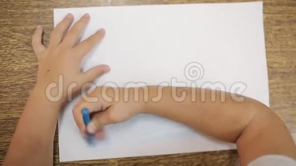 女孩用蓝色粉笔画画在白色的纸上画出海洋或海洋的艺术画女孩的手视频的预览图