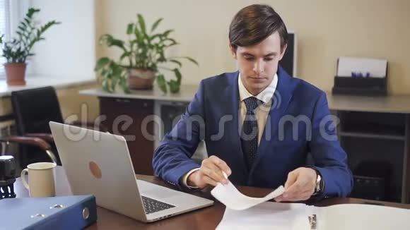 年轻的创业主管在办公室里的笔记本电脑上工作视频的预览图