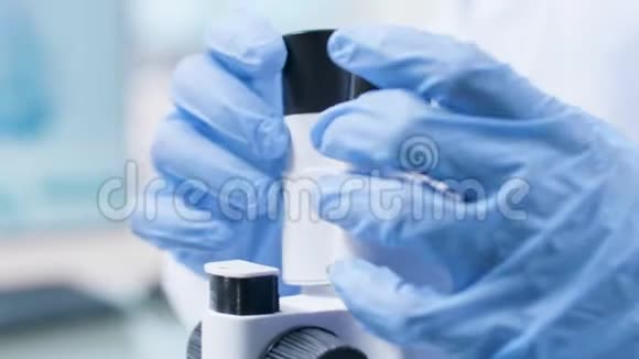 手持特写镜头的职业科学家在盖德尔看显微镜视频的预览图