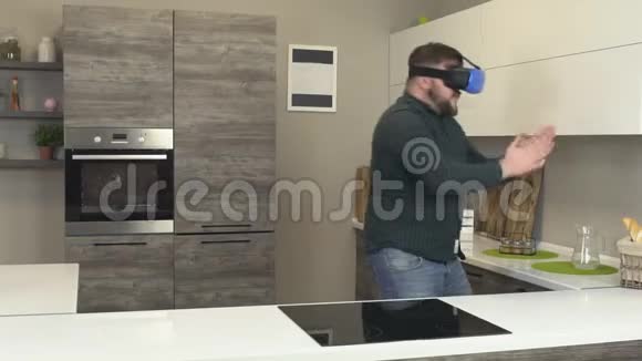 一个留着胡子的人在现代化的厨房里戴着虚拟现实眼镜时间流逝创新视频的预览图