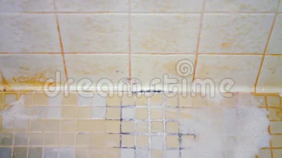 一个女人的手开始清洁一个恶心的淋浴地板上面覆盖着肥皂渣霉菌和霉菌视频的预览图