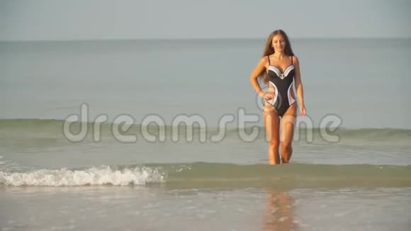 穿着泳衣的女孩走在海边视频的预览图