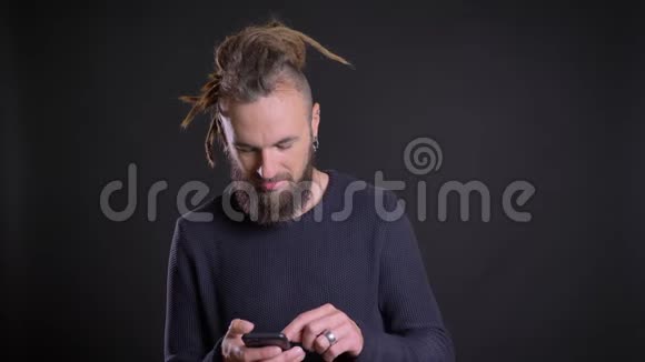 一张白种人的照片他戴着可怕的锁在黑色的智能手机上玩得很开心视频的预览图