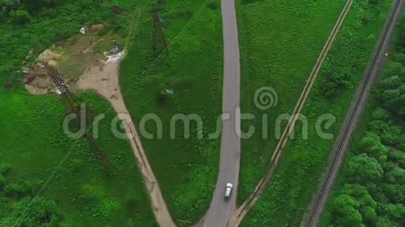 鸟瞰飞行和愚弄汽车沿着一个农村绿色地区行驶4K视频的预览图