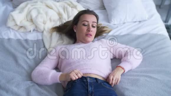 专注的女人强迫把牛仔裤关在床上视频的预览图