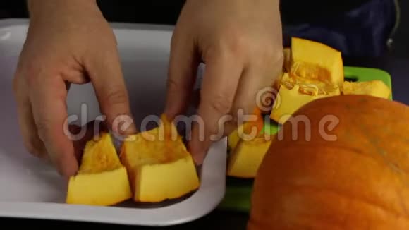 一个男人把一块橙色的南瓜放在托盘上世界素食日视频的预览图