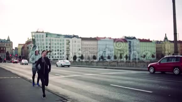 一对健康的夫妇在布拉格街头户外跑步慢动作视频的预览图