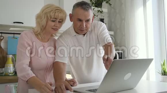 美国老年夫妇正在谈话成熟的老年人和女人喜欢网上购物视频的预览图