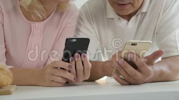 老年男性持手机老年女性在家使用智能手机视频的预览图