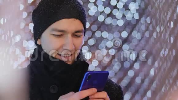 男人短信打字智能手机应用程序晚上圣诞节视频的预览图