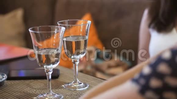 餐厅的桌子上摆着两杯白起泡酒两个女人在餐厅放松和交谈视频的预览图