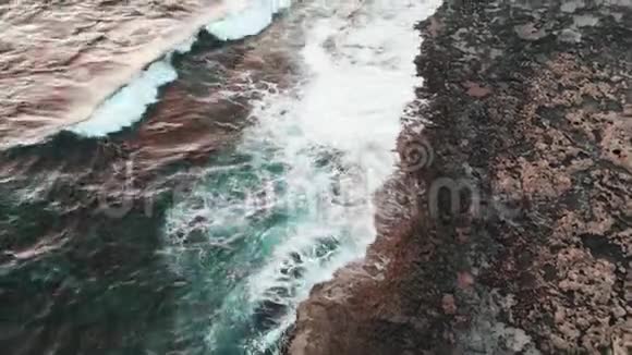 巨大的白色波浪在风暴中撞击岩石海岸空中无人机射击视频的预览图
