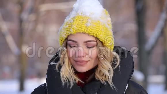 快乐的女人在冬日从头上扔下雪慢吞吞的视频的预览图