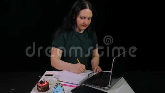 咖啡屋里的一个女人喝着黑背景的白色杯子里的咖啡在看日记时写日记视频的预览图